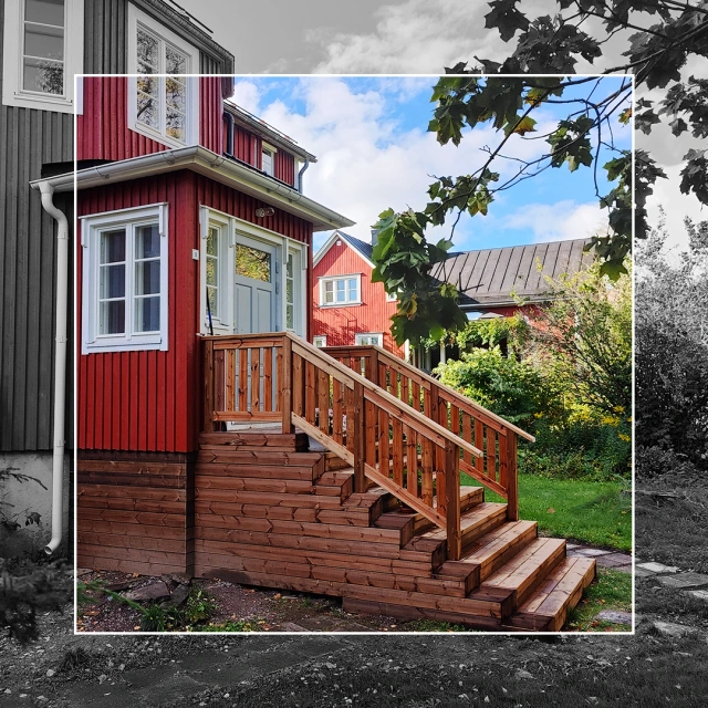 Kuvassa punainen talo, jonka edustalle on rakennettu puinen kuisti.